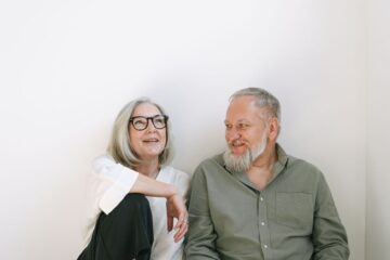 man and woman sitting on the floor discussing Medicare Advantage plans