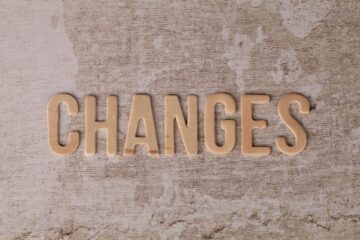 wooden letters spell out changes on textured background